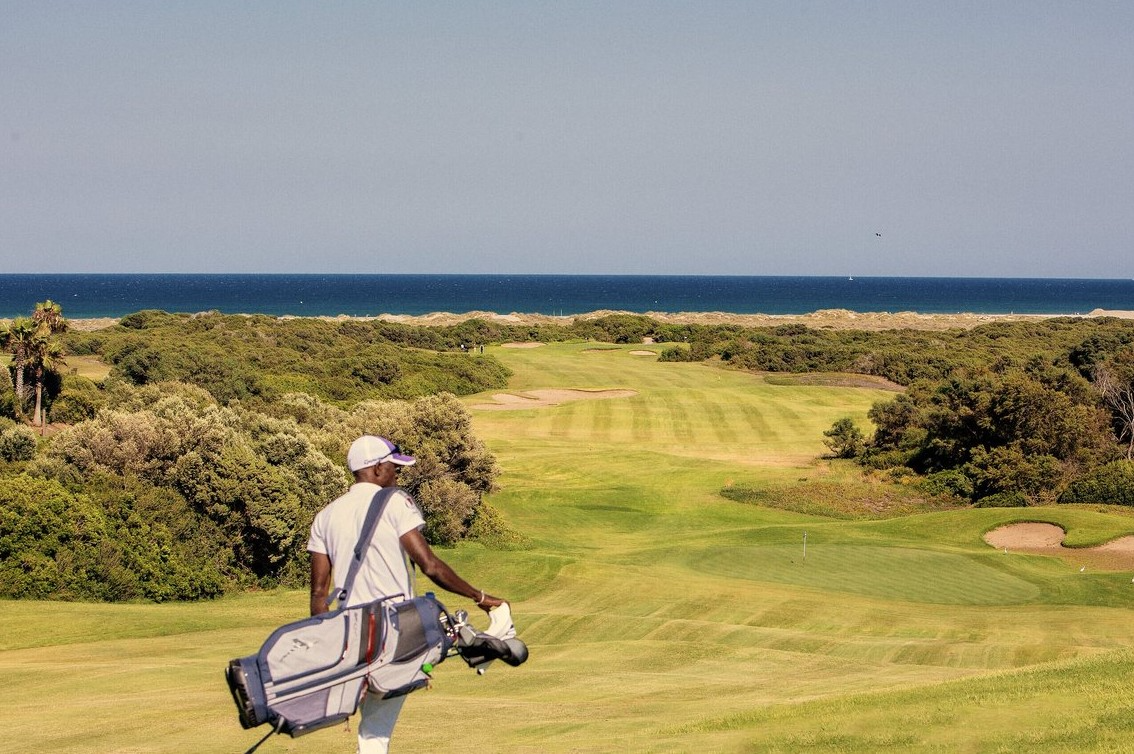 Golfeur transportant son sac au Club Med Yasmina, sur un terrain avec vue sur la Méditerranée. Golfeur transportant son sac au Club Med Yasmina, sur un terrain avec vue sur la Méditerranée.